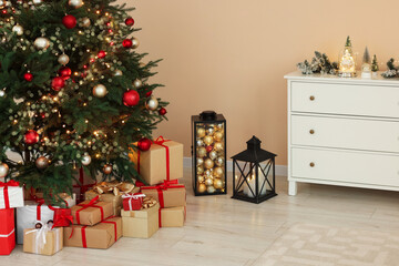 Beautiful tree decorated for Christmas and gift boxes in room. Interior design