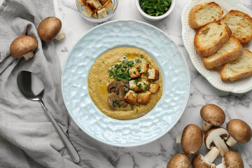 Delicious cream soup with mushrooms and croutons on white marble table, flat lay
