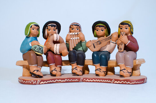 Peruvian handicraft in white background. Five musicians playing typical instruments seating on a bench (zampo&ntilde;a, charango, quena, horn and drums)