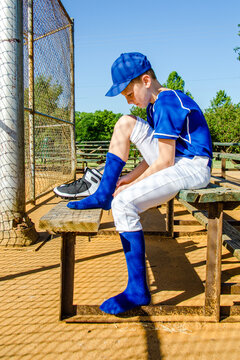 Young Youth Boy Little League Baseball Player Sitting on Bench Putting on Gear