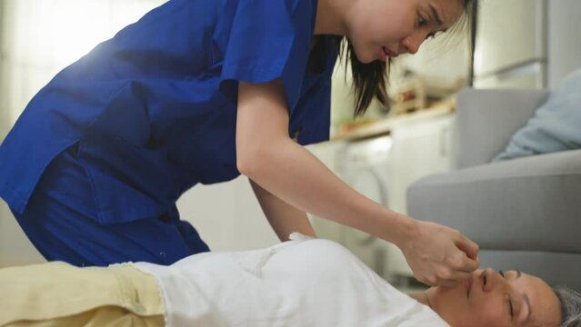 Asian caregiver saving senior woman's life by doing cpr in emergency.