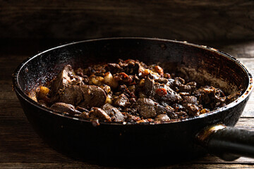 Fried chicken liver in a frying pan on the kitchen table.