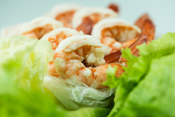 Shrimps boiled and peeled place on fresh lettuce. Selective focus