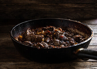Fried chicken liver in a frying pan on the kitchen table.