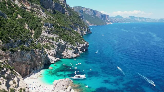 Boat Tour Excursion pick up Tourists at Cala Mariolu Beach, Baunei Coast, Sardinia, Italy - Aerial 4k