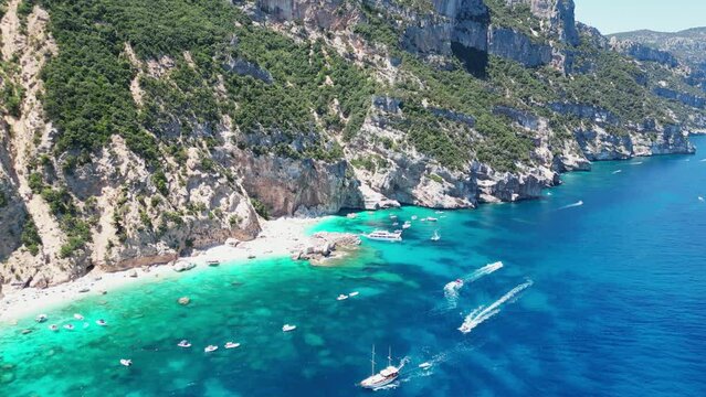 Boat Tour Excursions and Tourists at Cala Mariolu Beach, Baunei Coast, Sardinia, Italy - Aerial 4k