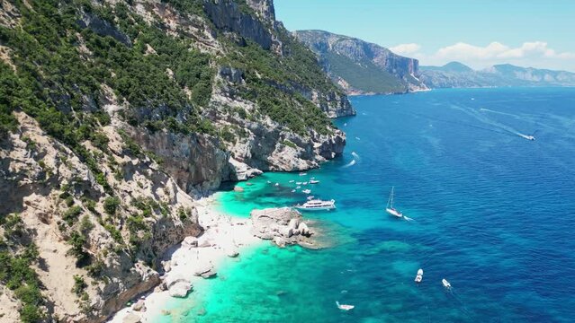 Boat Tour, Tourist People and Sandy Beach at Baunei Coast, Sardinia, Italy - Aerial 4k Tilting Down
