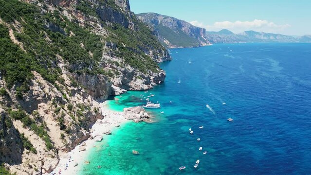 Cala Mariolu Beach, Tourists and Boats at Baunei Coast, Sardinia, Italy - Aerial 4k