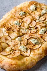 pizza with pear and Gorgonzola on Roman dough, pinsa macro close up vertical