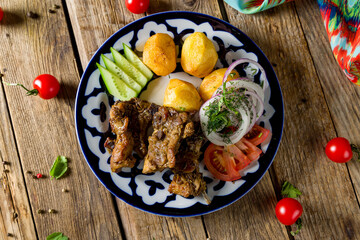 Kazan kebab on plate with beef and potatoes on wooden table top view