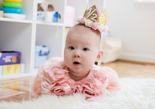 6-month-old baby girl. Half birthday. Happy birthday, princess. Cute caucasian baby girl in a pink dress. Tiara baby	