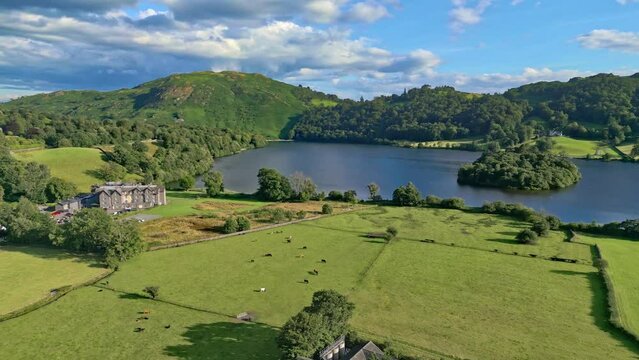 Cinematic summer aerial view of the Lakeland town of Grasmere. Showing the small lakeland town. Lake District National Park, Cumbria.