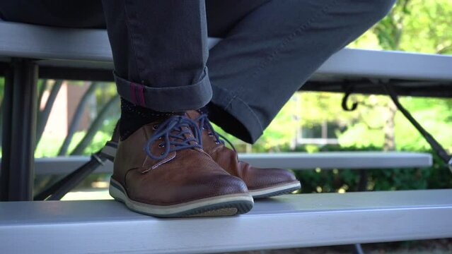 close up of brown leather shoes on bleachers