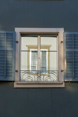 Fototapeta premium A window perfectly reflected inside of another window, amidst a dark blue wall