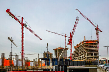 Large construction site with construction cranes working on a construction complex where...