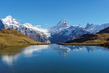Bachalpsee lake near First, Switzerland with snowy alpine range reflected in the water