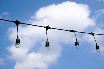 Clear string lights on blue sky background