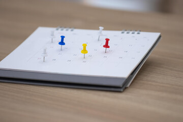 Closeup calendar page with drawing-pins , planning for business meeting or travel planning concept