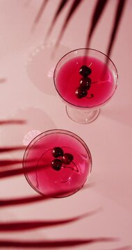 Vertical video of close up of drinks with cherries on white background, with copy space