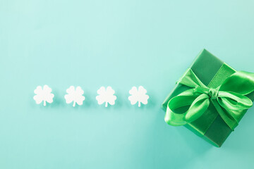 Happy St Patricks Day decoration background. above view gift box green clover leaves festive decor, shamrocks leaves holiday symbol with copy space on pastel background, Banner greeting card concept
