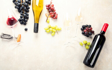 Flat-lay of red and white wine in glasses and corkscrews over grey concrete background, top view,...