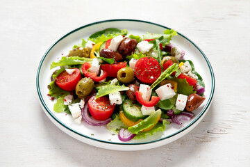 Greek village salad horiatiki with feta cheese, olives, cherry tomato, cucumber and red onion, vegeterian mediterranean food, low calories dieting meal.