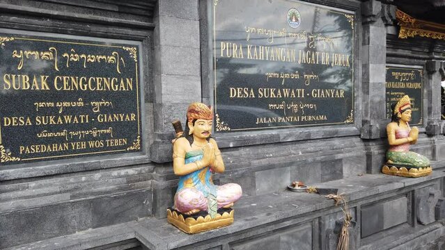 Balinese Statue of Bali People Praying, at The entrance of Sukawati Temple in Purnama Beach, Wearing Colorful Traditional Clothes, Indonesia, Southeast Asia, Hinduism