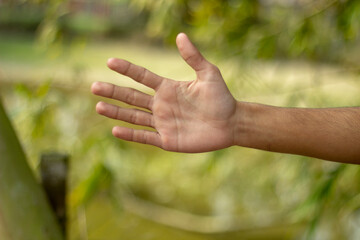 a man show his own hand and the background is blurred