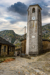 Fototapeta premium The picturesque village of Tsepelovo during fall season with its architectural traditional old stone buildings and the famous clock tower, located on Tymfi mount, Zagori, Epirus, Greece, Europe