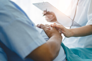 Doctor touching hands to encouragement mental of elderly patient after surgery at bed in hospital.