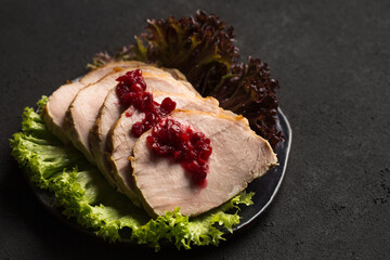 Delicious juicy sliced ham with lettuce with acid sweet lingonberry sauce