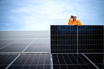 Portrait of worker holding solar panel inside power plant.