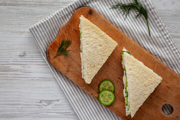 Homemade English Cucumber Sandwiches on a rustic wooden board, top view. Copy space.