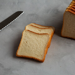 Sliced Whole Wheat White Bread on a gray background, low angle view.