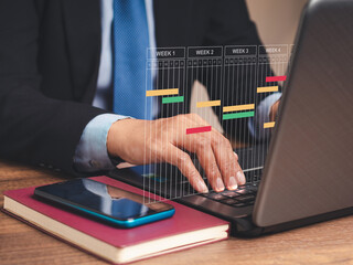 Business project management concept. A project manager works on a laptop, updates tasks, and...