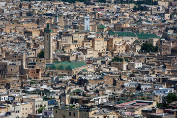 Fototapeta na wymiar The green striped minaret of R'cif Mosque stands tall above the old city (medina) of Fez in Morocco.