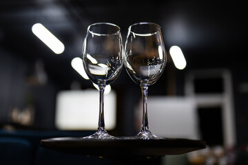Two clean empty glasses on the table before the wine tasting. Beautiful light falls on the glass