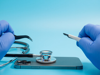 Smartphone and medical stethoscope. Smartphone diagnostics and repair. Medical stethoscope on smartphone blue background.