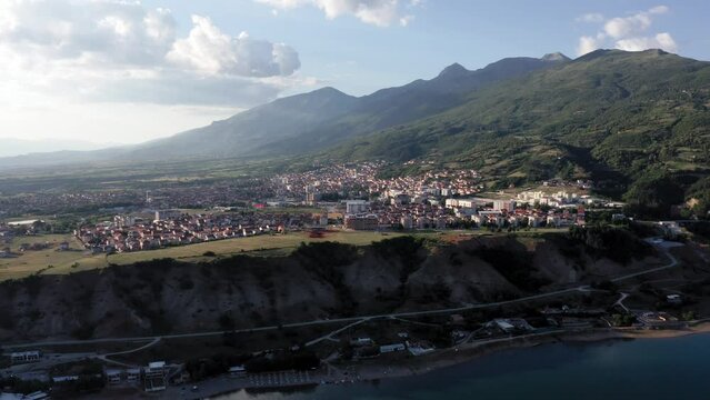 Drone lifting shot of the city of Debar on the reservoir Black Drin against the high mountains of North Macedonia nature