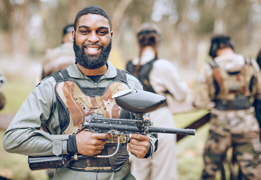 Paintball, gun and portrait of black man with smile ready for game, match and shooting battle outdoors. Extreme sports, adventure and male in camouflage, military clothes and action gear for arena