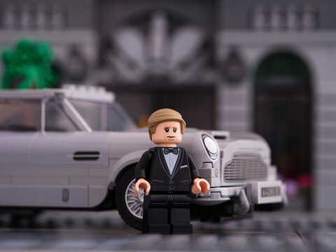 Tambov, Russian Federation - January 06, 2023 A Lego No Time to Die-James Bond minifigure standing near his 007 Aston Martin DB5 car by LEGO Speed Champions on city street.