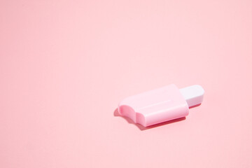 Pink ice cream toy made from plastic on pink background with copy space