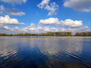 white clouds and blue sky reflected in the Danube river