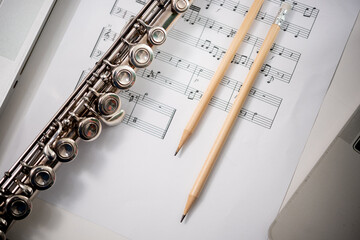 Flute musical instrument : Silver modern flute on white sheet music note for education and...