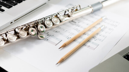 Flute musical instrument : Silver modern flute on white sheet music note for education and...