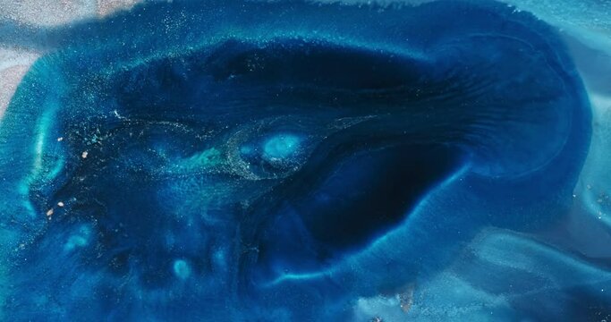 Dark blue paint flowing abstract background. Dark aquamarine blue flow abyss 4k video. Deep art ink. Shiny blue liquid. Acrylic texture in motion. Glitter fluid pattern. Sparkling moving backdrop