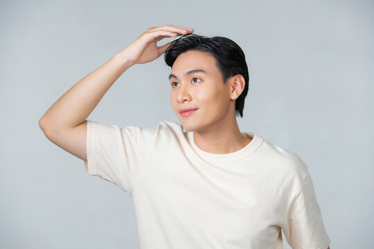 Handsome man touching his hair close up portrait studio on white background