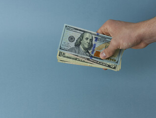 Paper bills, dollars in a man's hand on a colored background. 