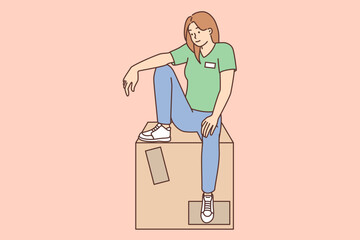 Woman shop assistant sits on large box with new goods brought for sale