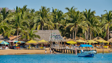 man walking on a boat in the sea with an island in the background